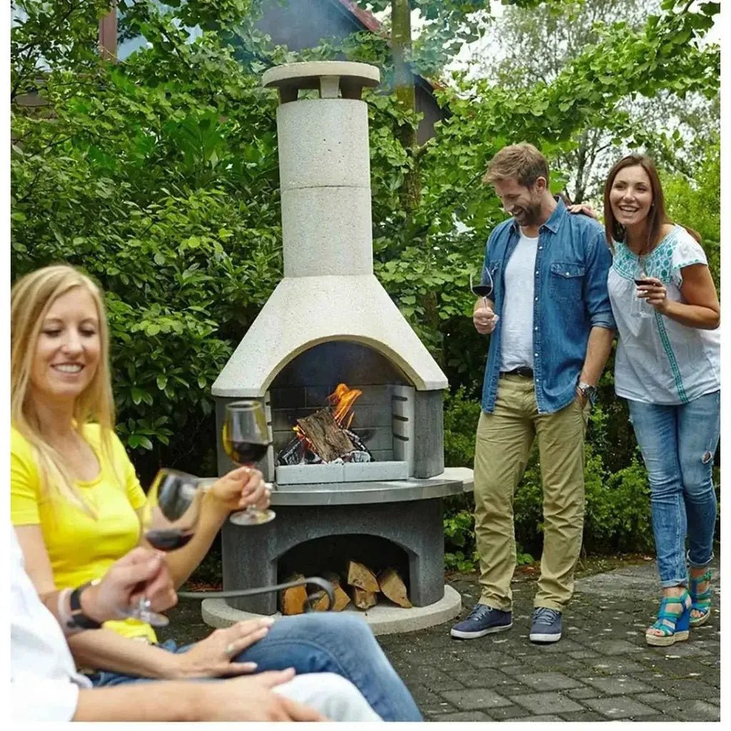 Gray stone outdoor fireplace with chimney and firewood storage compartment buschbeck wellington masonry barbecue