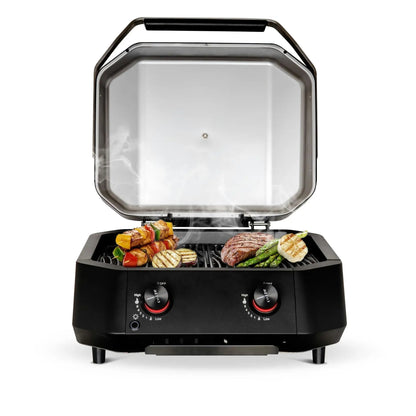 Black Cozze G-500 gas grill with 2 zones 5.0 kW transparent lid and temperature control knobs cooking steak vegetables and skewers