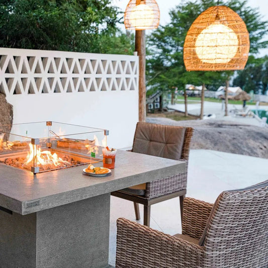 Gray concrete Elementi Birmingham dining fire table with 13.2 kW flames enclosed in glass for outdoor use