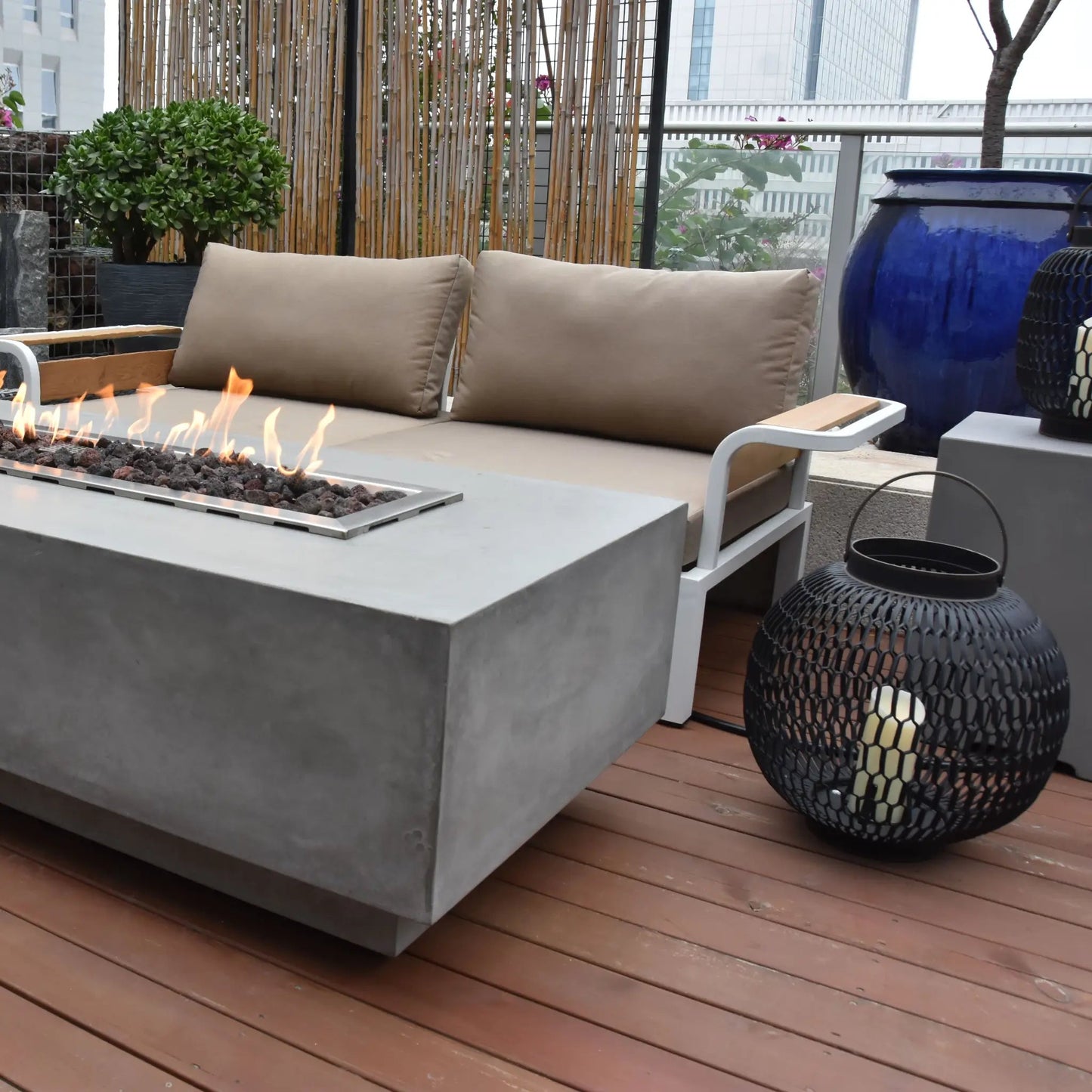 Gray concrete fire pit with rectangular metal frame and burning flames elementi granville fire table 13.2 kw