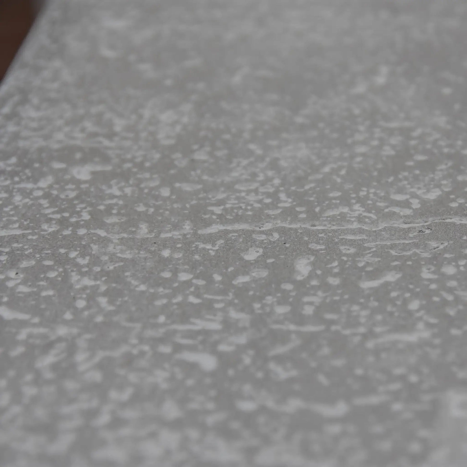 Gray textured surface with a speckled pattern on the elementi hampton fire table 13.2 kw model ofg139lg