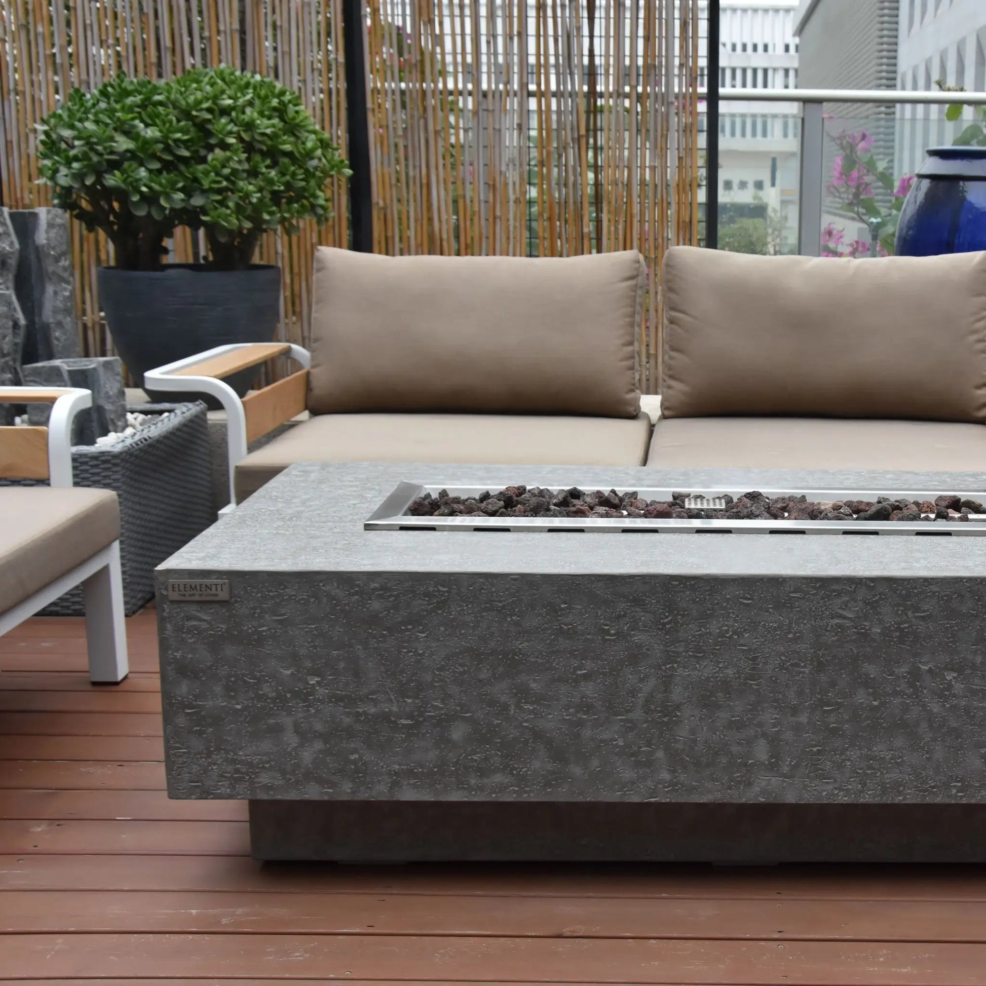 Elementi Kingsale fire table gray concrete with rectangular metal insert holding dark pebbles 13.2 kW heating