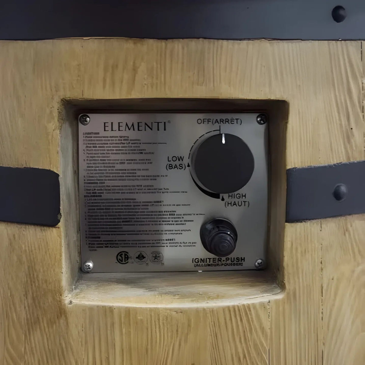 Silver control panel with black rotary dials labeled off low and high on wooden surface of elementi lafite barrel bar fire table