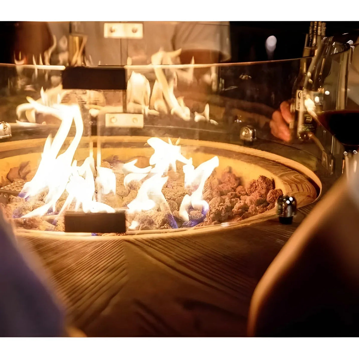 Elementi lafite barrel bar fire table with 13.2 kw circular glass-enclosed fire pit and glowing volcanic rocks on wooden base