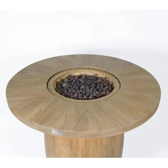 Light-colored wooden Elementi Lafite Barrel Bar fire table with circular top and central burner filled with gray lava rocks