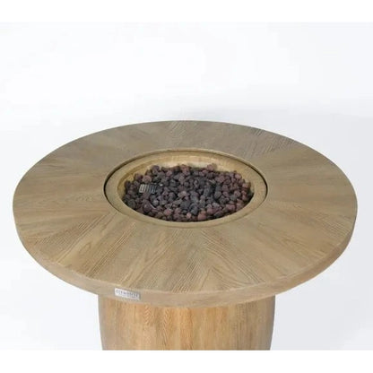 Light-colored wooden Elementi Lafite Barrel Bar fire table with circular top and central burner filled with gray lava rocks