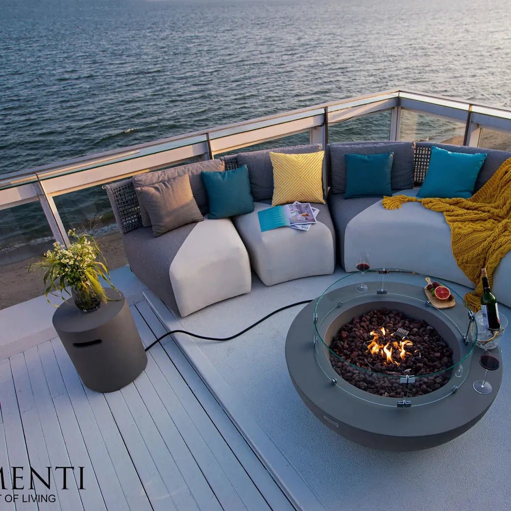 Modern gray elementi lunar bowl fire table with glass top and burning coals for outdoor heating and ambiance