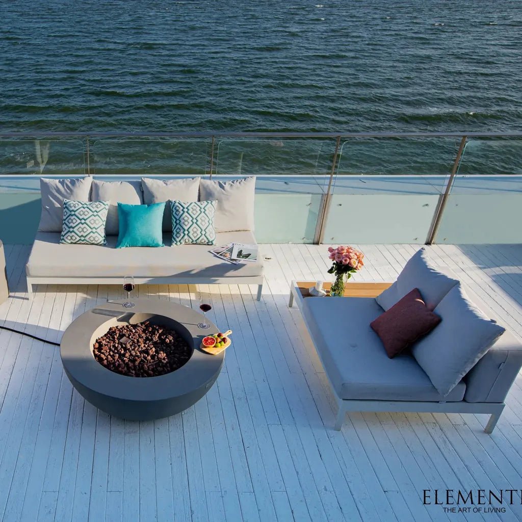 Elementi lunar bowl fire table in light grey concrete with dark brown pebbles inside for outdoor use