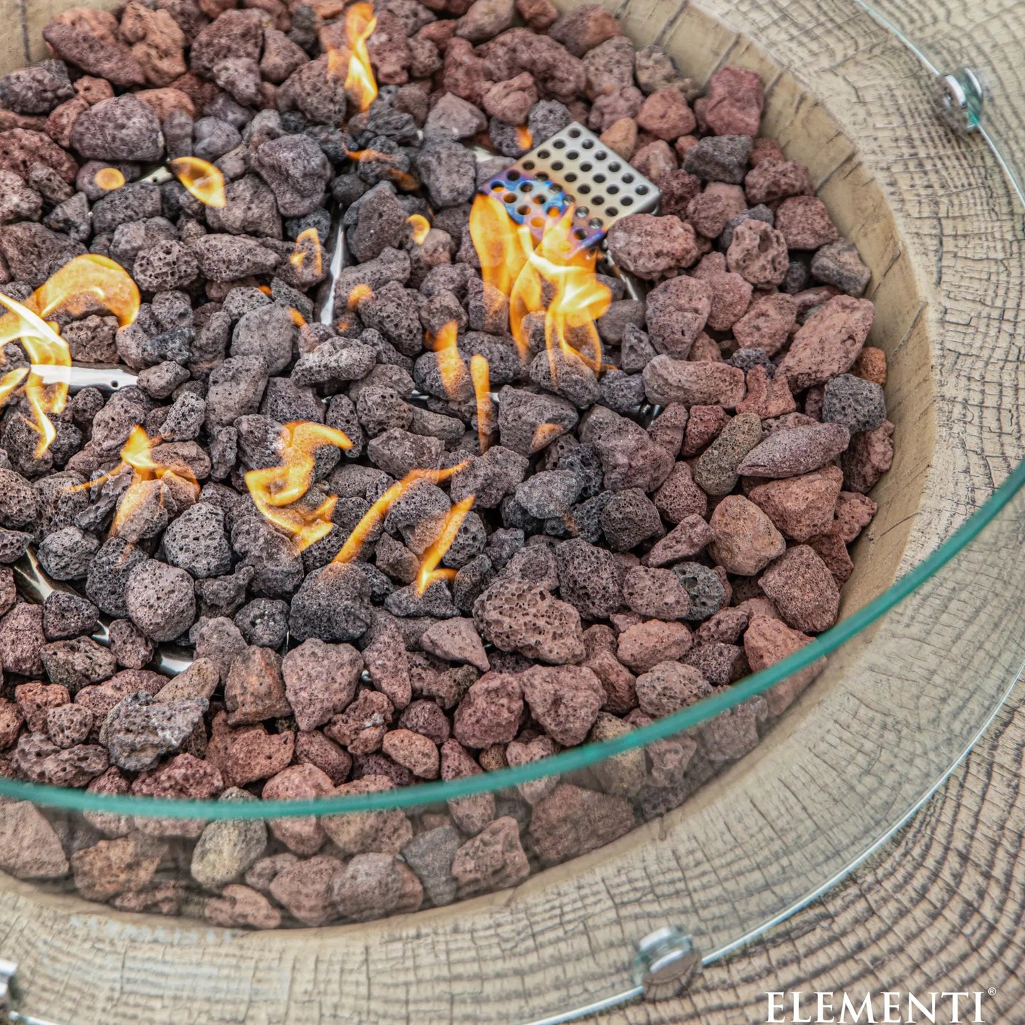 Elementi Manchester fire table with glass rim 13.2 kW burner and reddish brown dark gray lava rocks in circular fire pit
