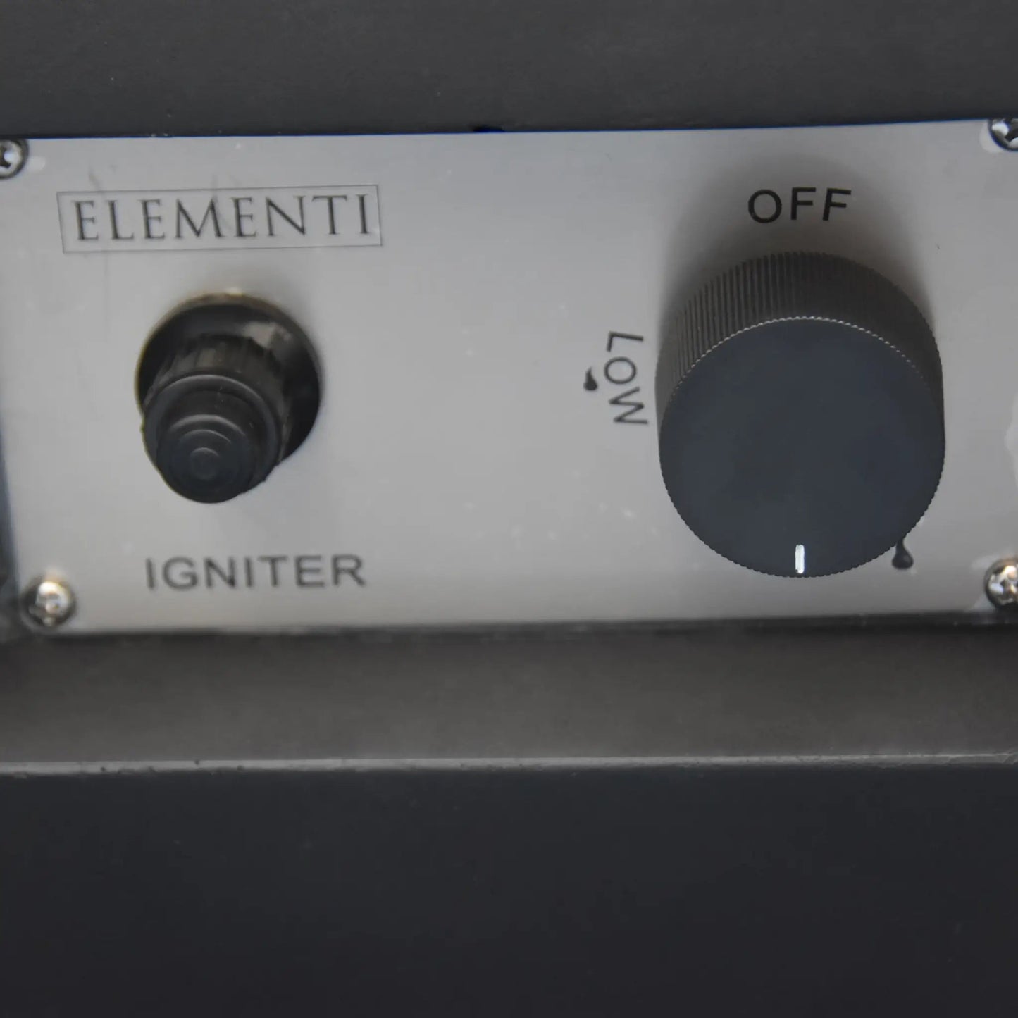 Silver control panel with black ignition button and rotary dial marked off and low on elementi modeno aurora fire table