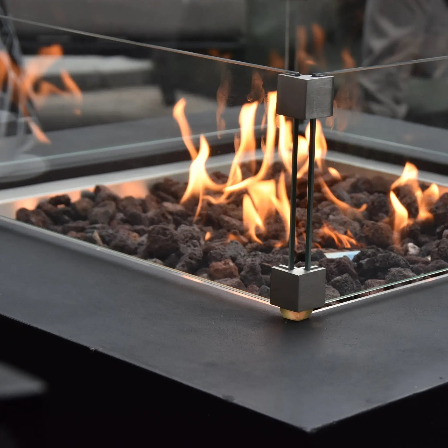 Elementi Modeno Aurora fire table with sleek black metal frame and glass enclosure featuring a central burner assembly