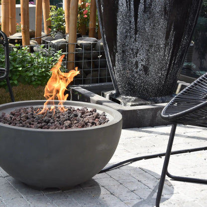 Gray concrete Elementi Modeno Nantucket fire bowl with glowing orange flames over dark volcanic rocks 11.7 kW
