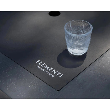 A clear textured glass tumbler with frosted finish on a sleek black surface beside elementi plus cannes fire table 16 kW