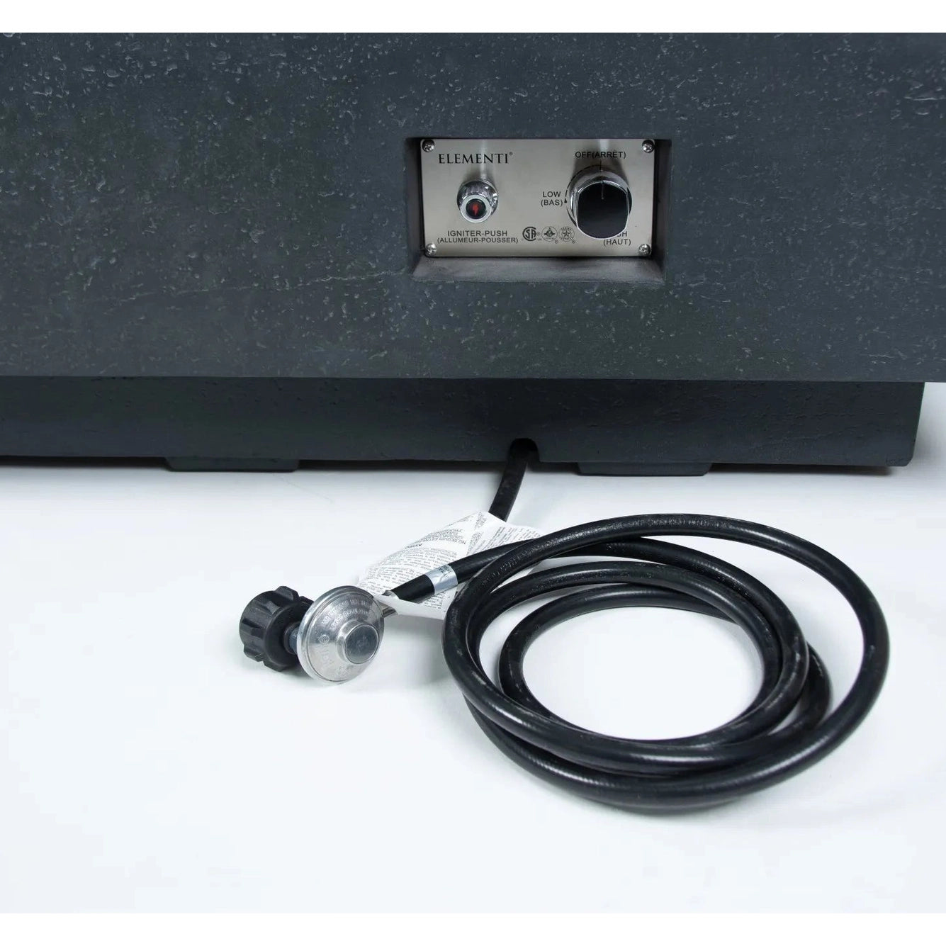 Black coiled gas hose with silver and black regulator attached beside the back panel of elementi plus cannes fire table