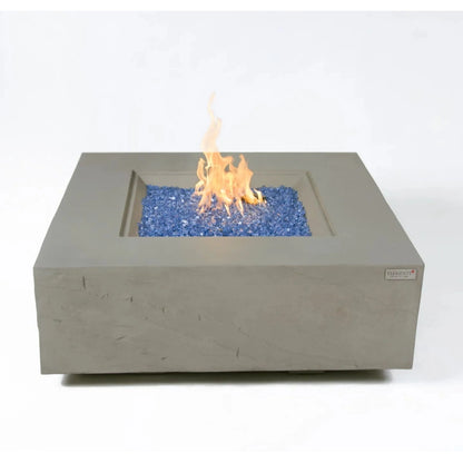 Gray concrete square fire pit Elementi Plus Capertee fire table with central flame over blue glass beads 16 kW