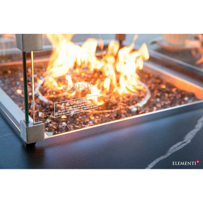 Elementi Plus Copenhagen porcelain top fire table with metallic frame and clear glass enclosure featuring glowing flames