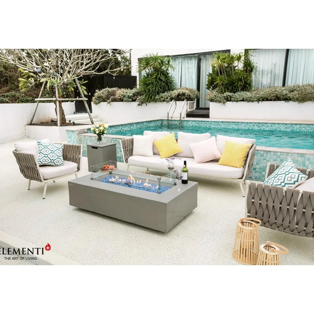 Gray rectangular Elementi Plus Meteora fire table with blue flame and glass top 16 kW OFG410SG model