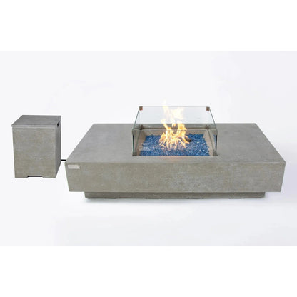 Modern concrete Elementi Plus Monte Carlo fire table with glass enclosure and blue decorative stones 16 kW