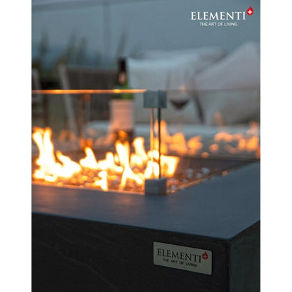Dark gray rectangular Elementi Plus Roraima fire table with glowing orange flames and a silver metallic Elementi plaque