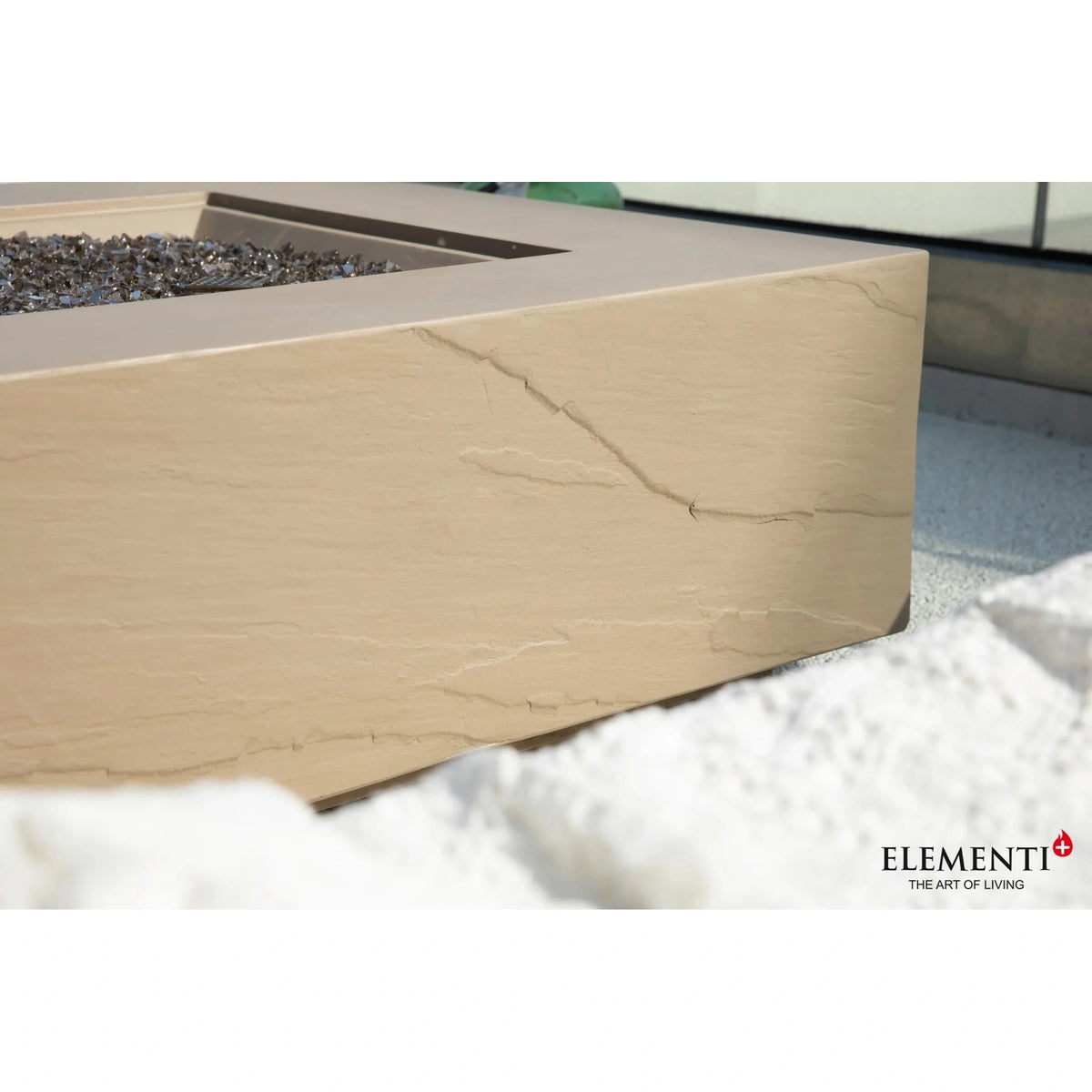 Elementi Plus Uluru fire table with 16 kW heat output featuring a beige stone fire pit with crackled texture and gray glass beads