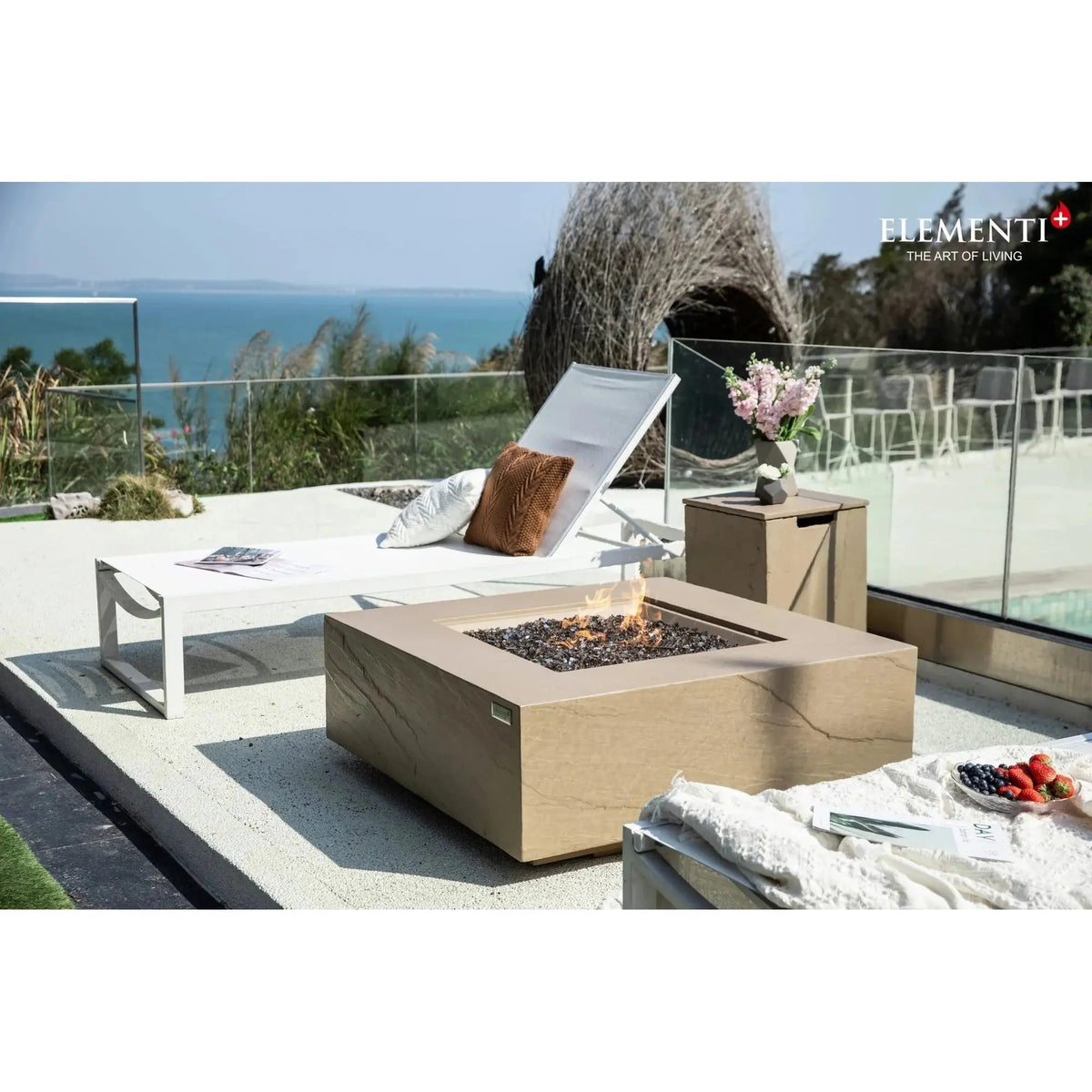 Beige stone Elementi Plus Uluru fire table with square design and glowing embers producing 16 kW heat output