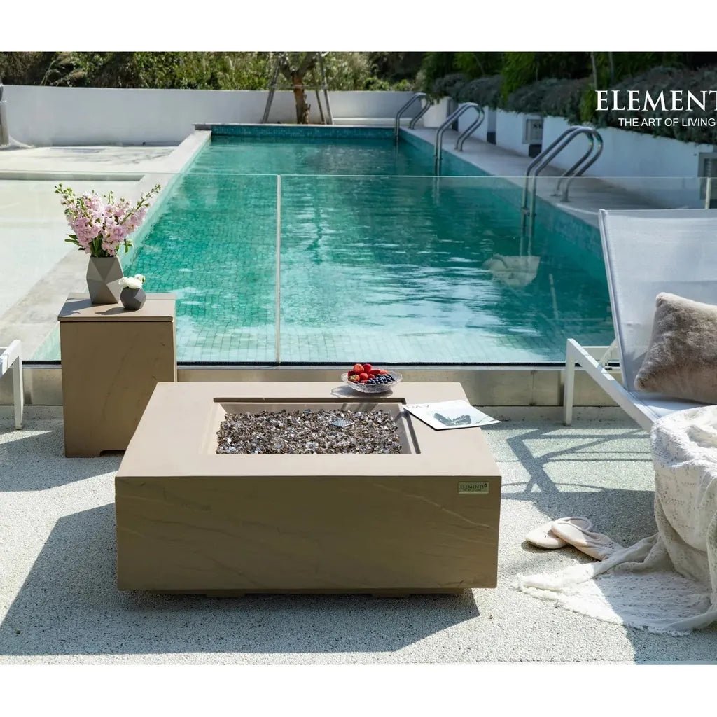 Beige rectangular Elementi Plus Uluru fire table with stone-like finish and dark gray pebbles inside 16 kW model