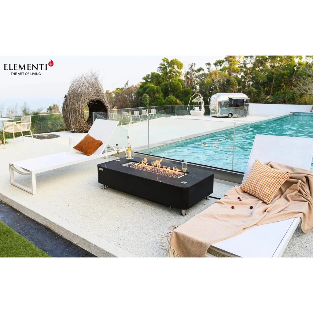 Black rectangular Elementi Plus Valencia fire table with glass top and metal legs producing 16 kW heat output