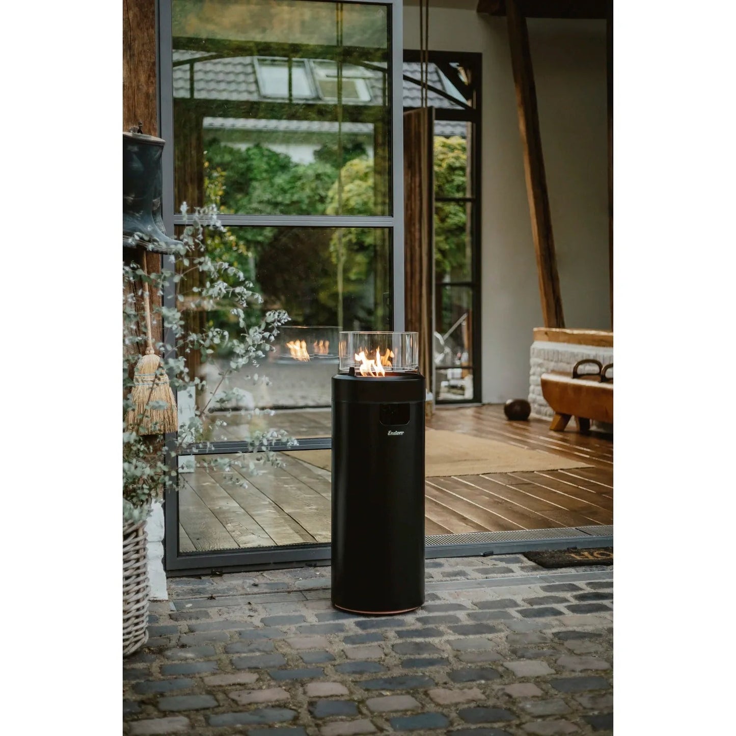 Black cylindrical Enders large NOVA LED flame patio heater with glass top and fueled branding with visible flame