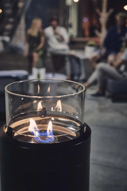 Enders large black nova led flame patio heater with black cylindrical outdoor fire pit and blue flame on clear glass top