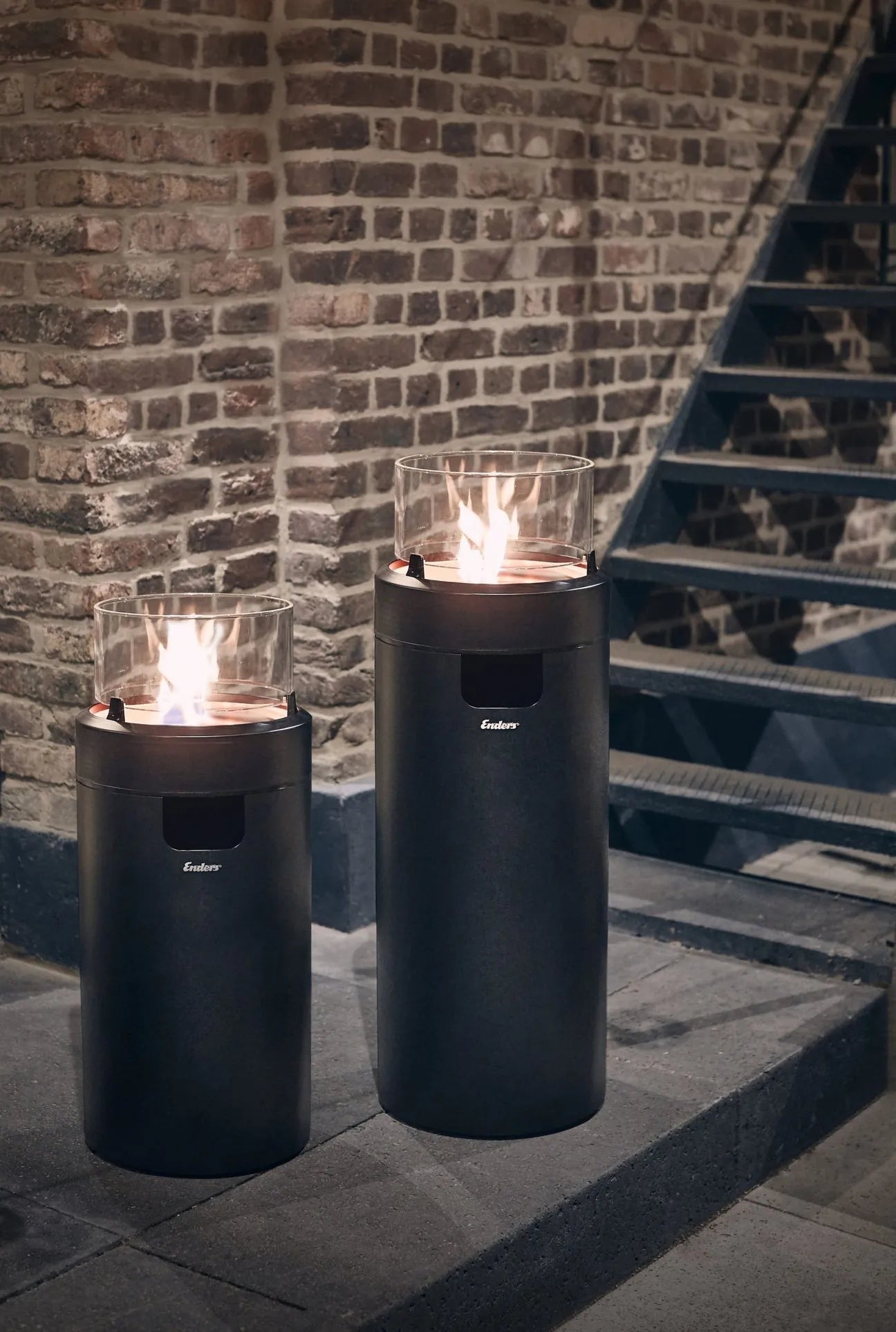 Two black ember gas fire pits with glass tops and glowing flames from Enders large black nova led flame patio heater EN5601