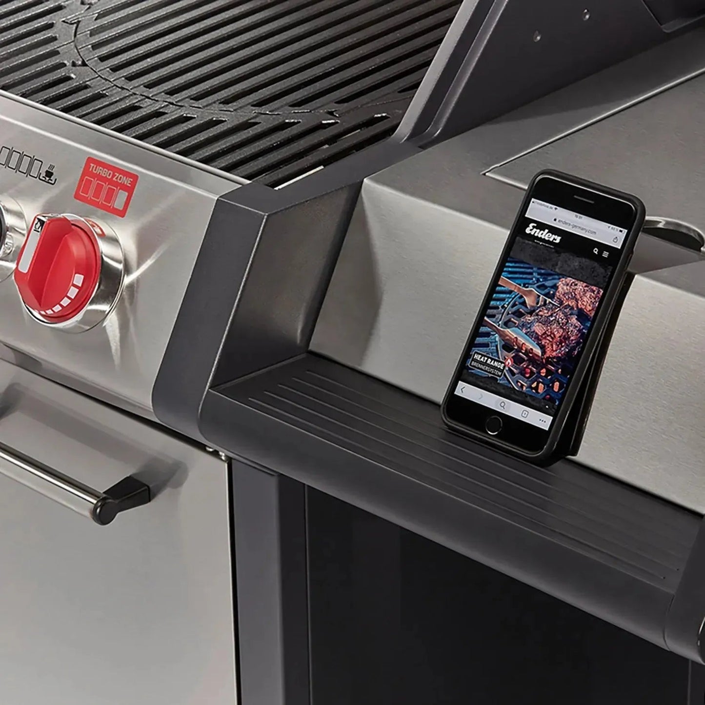 Black smartphone resting on stainless steel side shelf of Enders Monroe Pro 3 Sik gas barbecue EN83766 grill