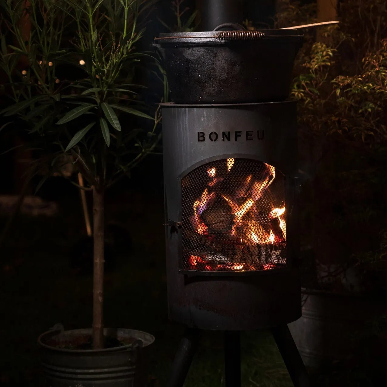 Black metal bonfeu bongiano sp outdoor fireplace with mesh front and glowing embers inside for outdoor use