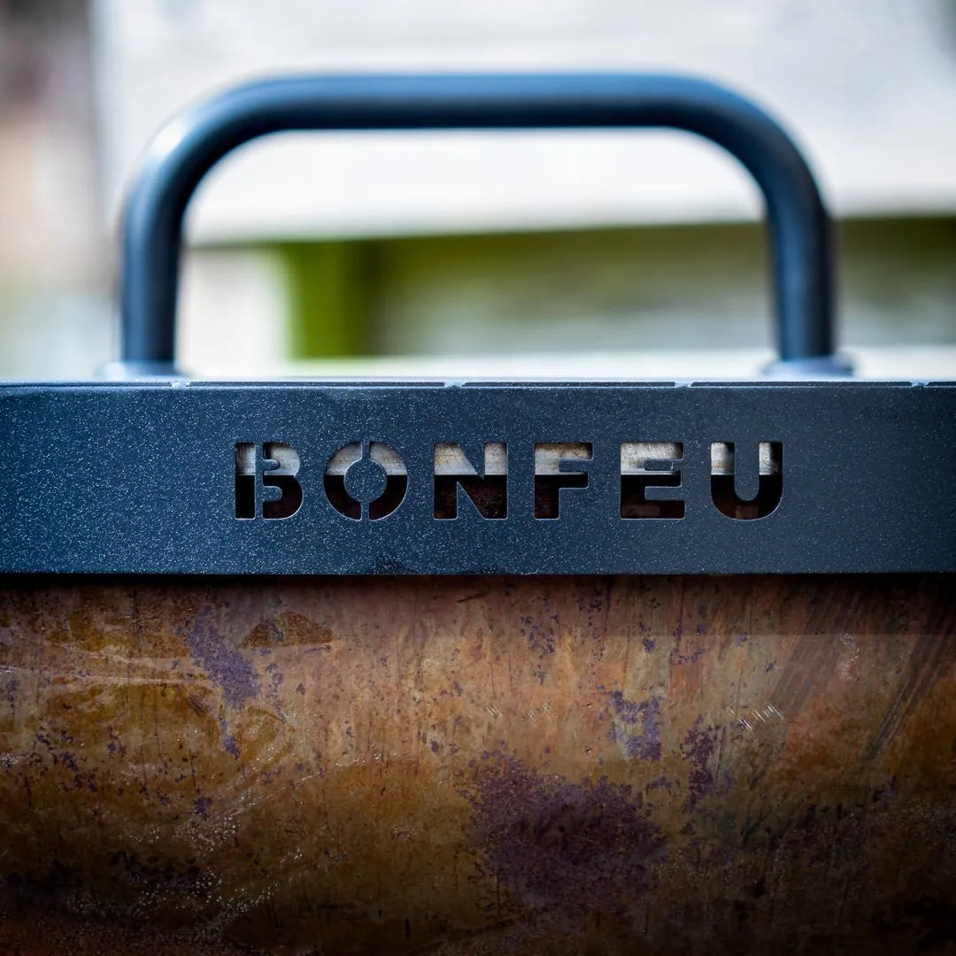 Black metal handle with bonfeu cut-out on bonfeu bonbiza open plancha grill fire pit in corten steel