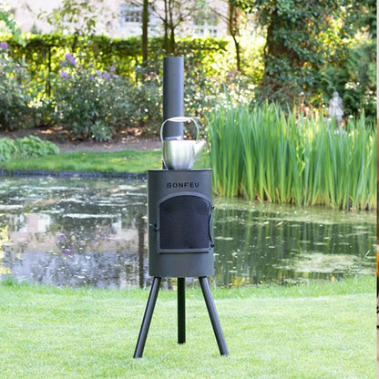 Black metal bonfeu bongiano sp outdoor fireplace with tripod legs, tall chimney, mesh door, and silver kettle on top