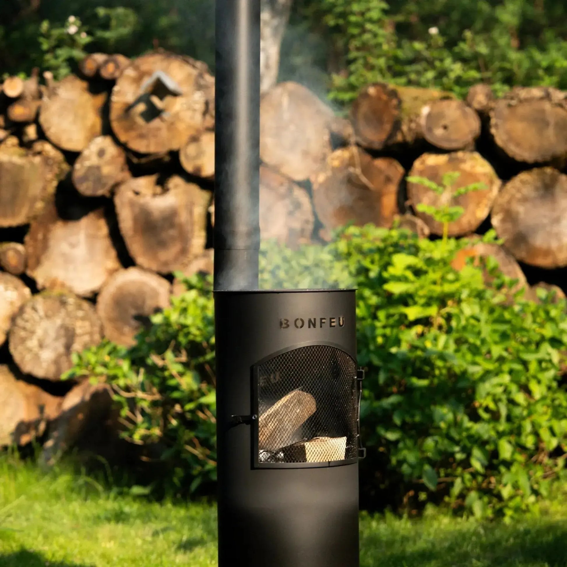Black metal bonfeu bongiano lp outdoor wood-burning stove with mesh door and smoke rising from its chimney