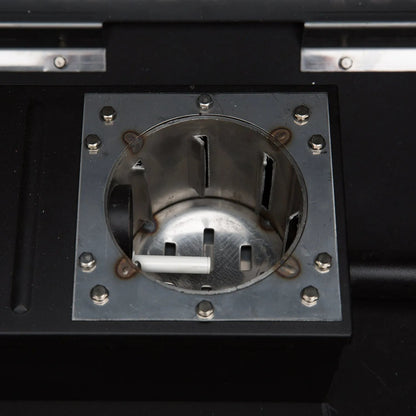 A white cylindrical cigarette resting inside a metallic receptacle of the gmg ledge prime plus wiFi pellet grill smoker
