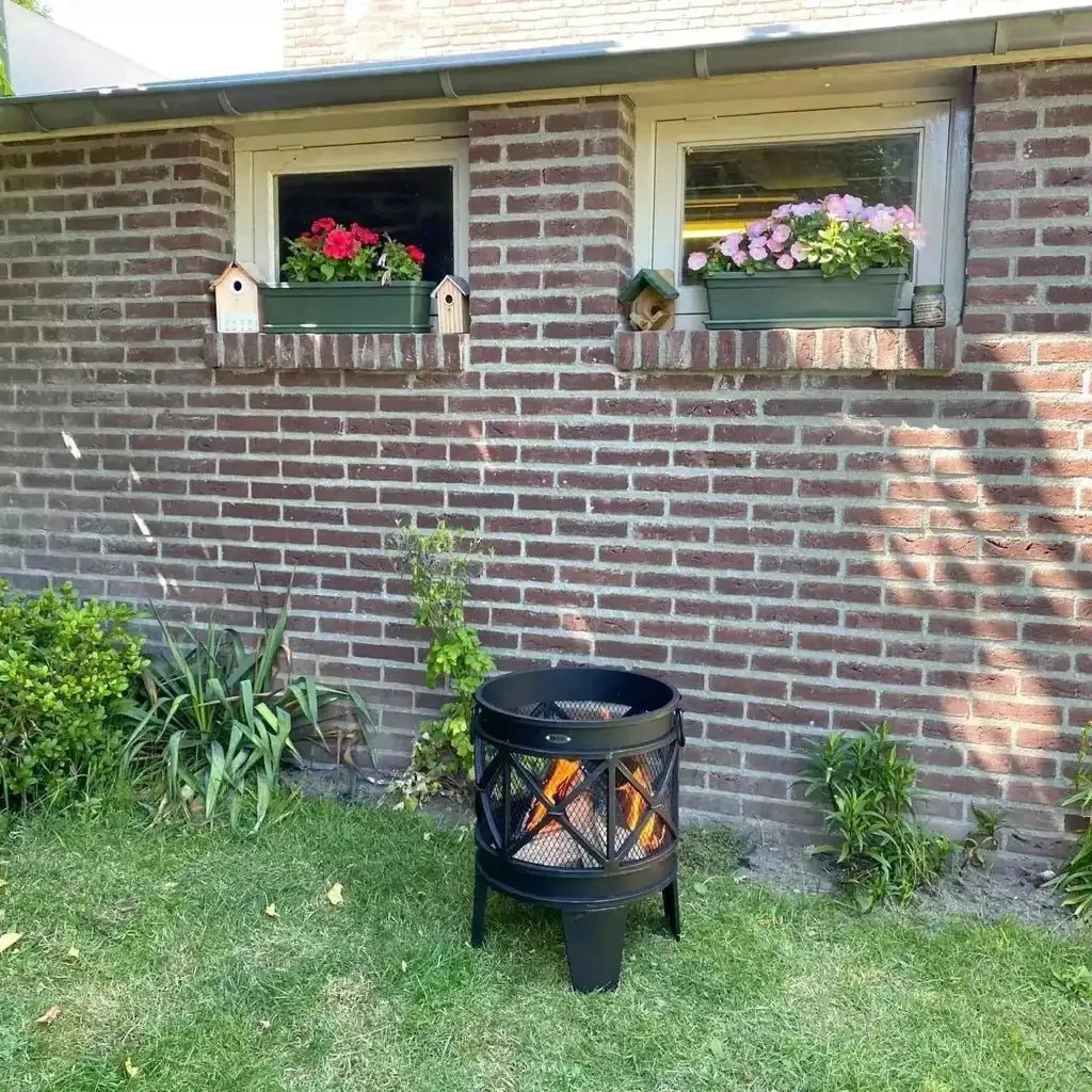 Black metal heat firecask fire basket with lattice design burning logs inside for outdoor fire pit use