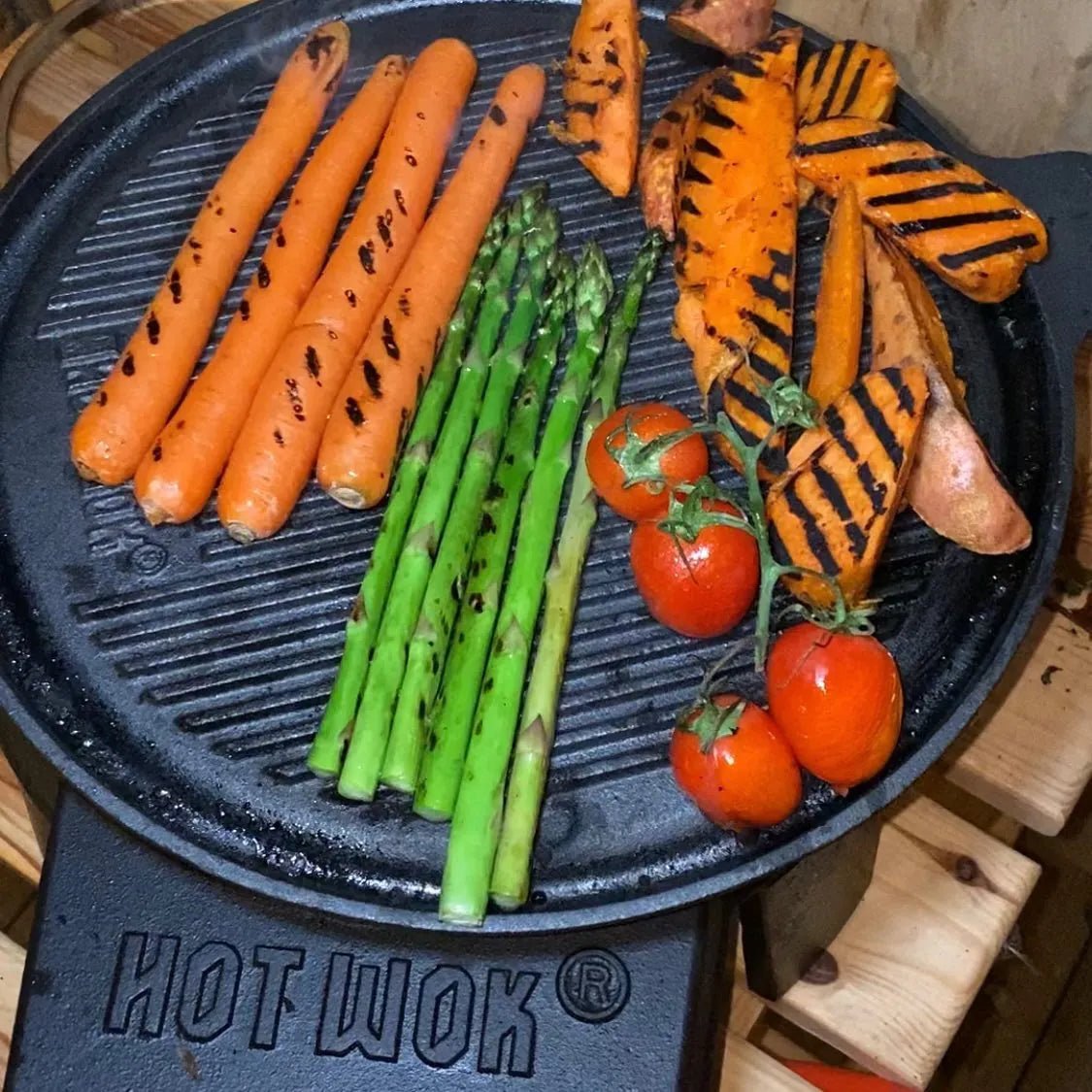 Black cast iron hot wok grill pan 32.5cm with grilled carrots asparagus sweet potatoes and cherry tomatoes hw6731