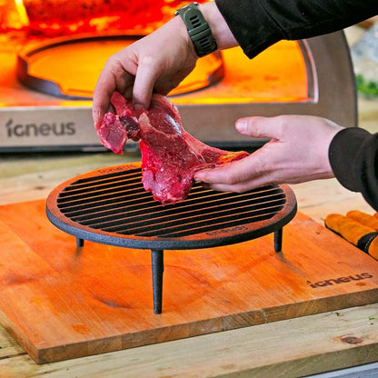 Black cast iron igneus tuscan grill with three legs and circular cooking grate for pizza oven use