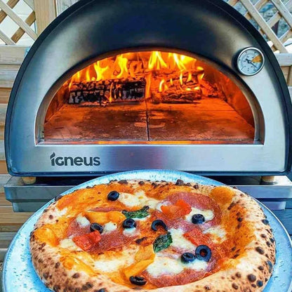 A freshly baked pizza with a golden crust on a metal tray in front of the igneus classico wood fired pizza oven