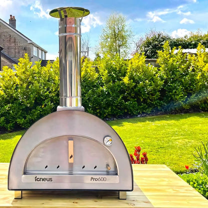 Stainless steel Igneus Pro 600 wood fired outdoor pizza oven with a tall chimney and arched door in silver finish