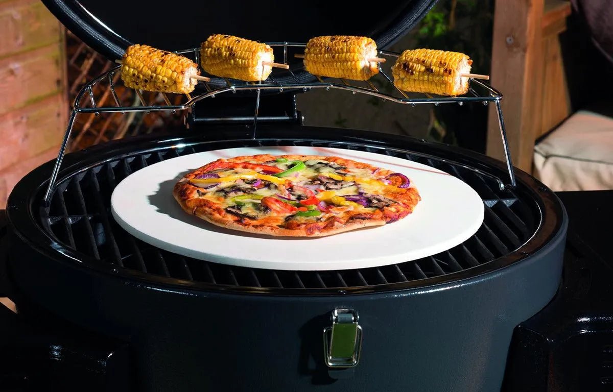 Lifestyle dragon egg charcoal bbq lfs300 with white ceramic pizza stone and freshly baked vegetable pizza on top