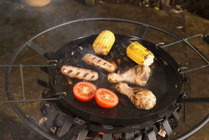 Black circular grill pan with metal grates cooking food on Lifestyle Signa firepit brazier with grill LFS703