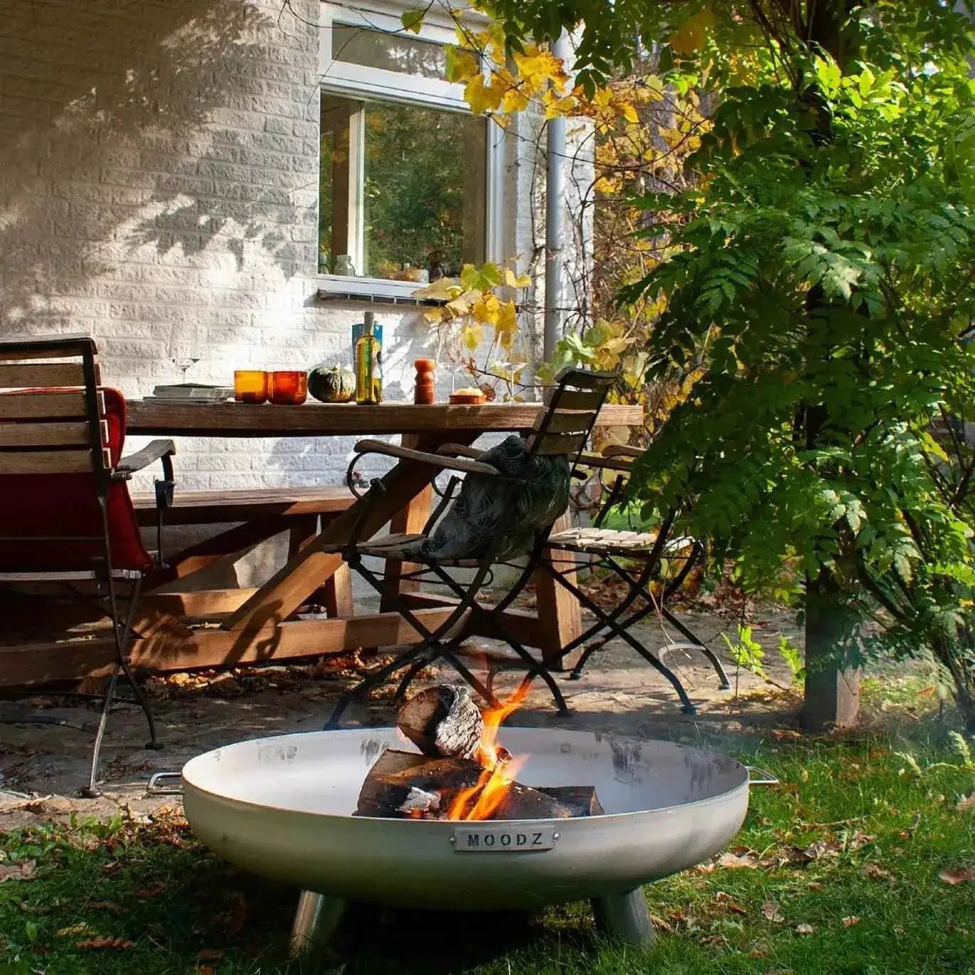 Silver metal fire pit with sleek modern design and moodz engraving from the moodz feet and handle fire bowls collection