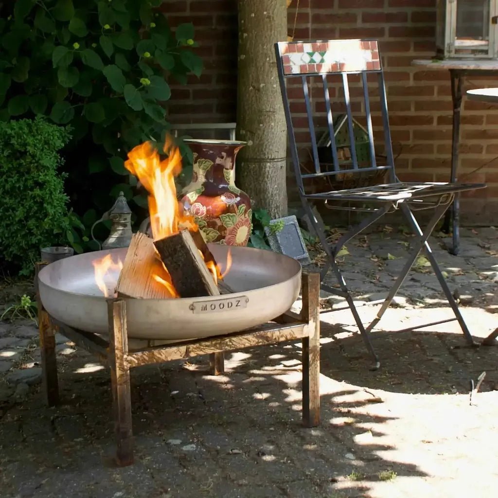 A sleek metallic matte finish moodz frame for garden fire bowls in stainless or carbon steel with engraved brand name