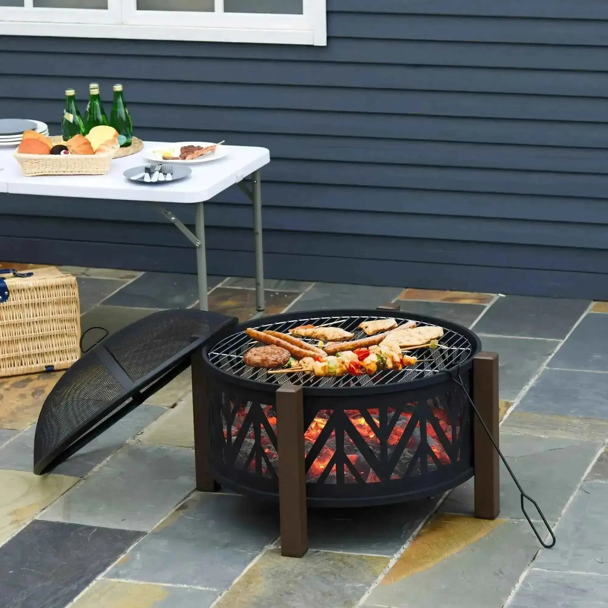 Outsunny black metal fire pit with wooden legs mesh lid open design showing glowing embers under grilling grate