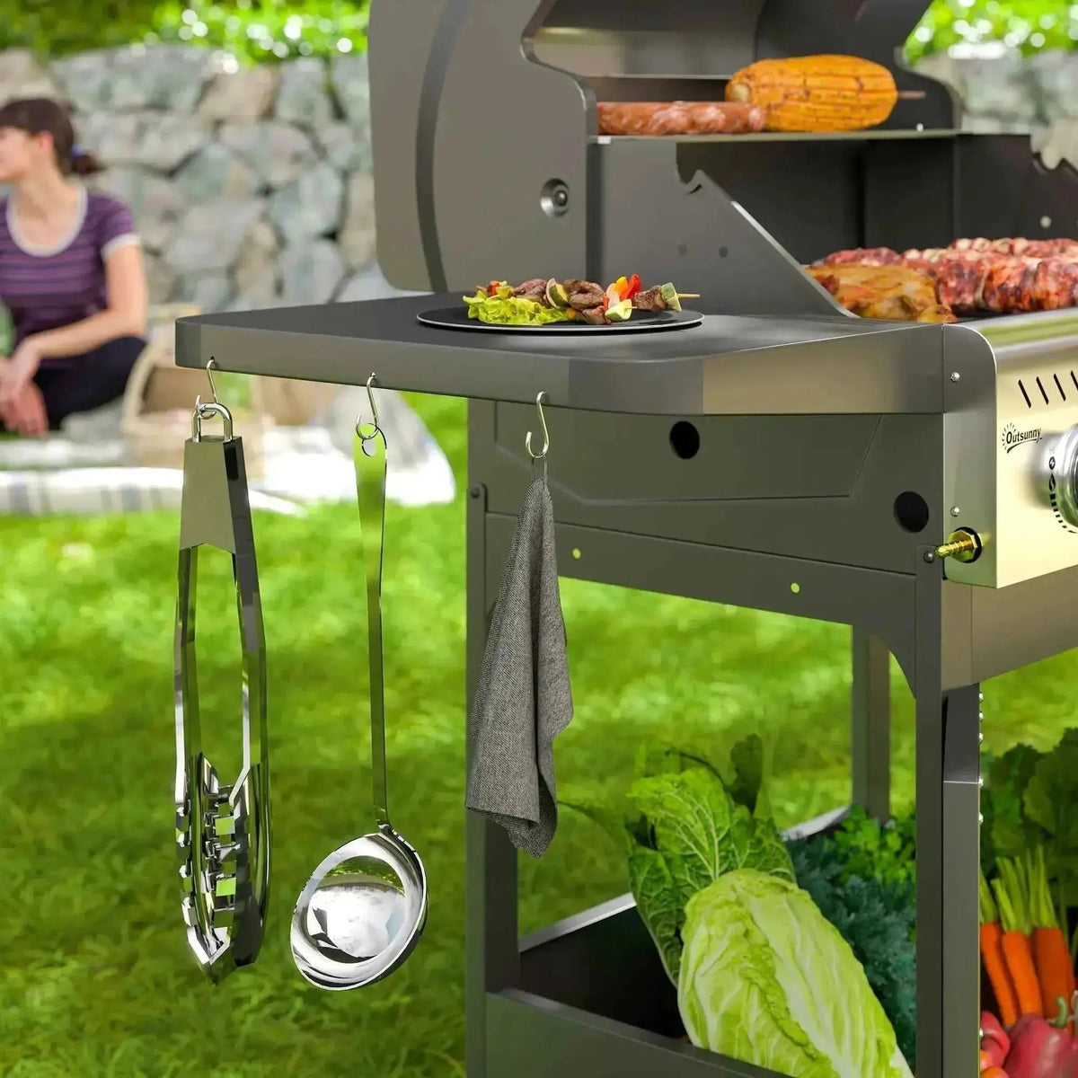 Stainless steel tongs with ergonomic handles hanging on the black outsunny 7.5kW 3-burner gas bbq grill with window lid