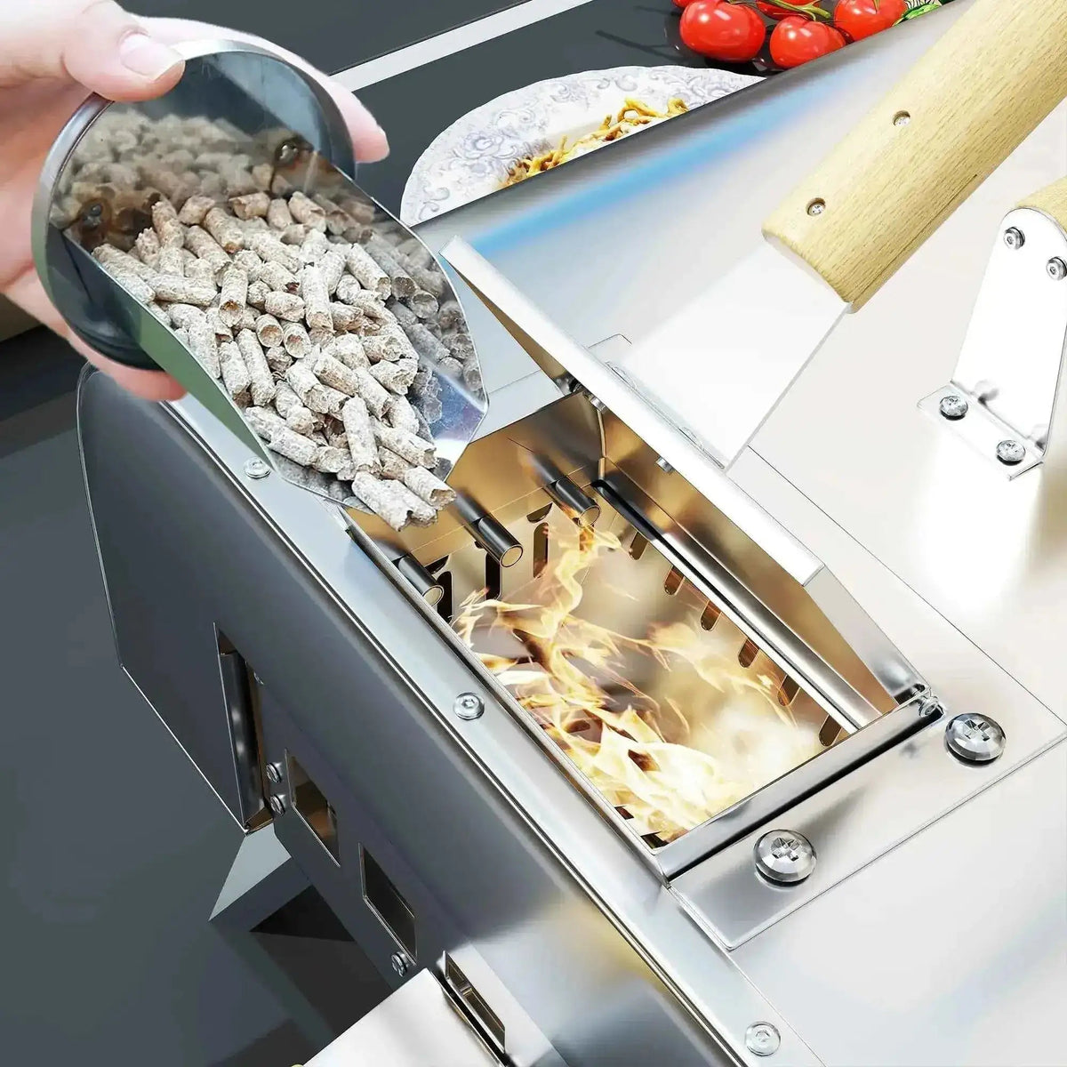A hand holds a metallic scoop of gray wood pellets above a burning stainless steel Outsunny outdoor pizza oven