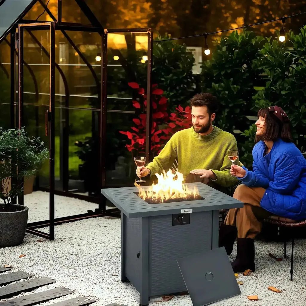 Outsunny rattan propane gas fire pit table in grey with a lit flame and control panel for outdoor heating