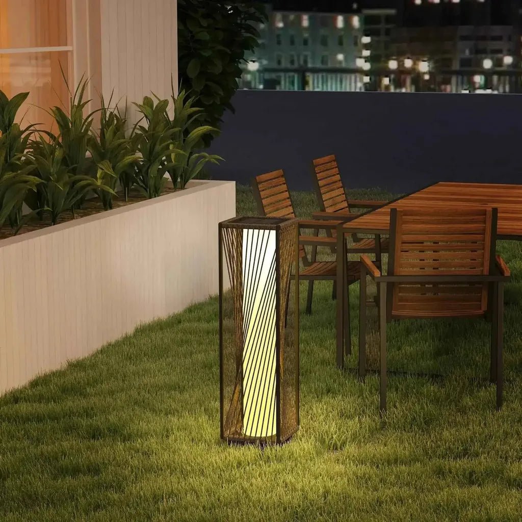 Outsunny rattan solar floor lamp with dark metal frame and vertical woven slats emitting warm yellow light in grey